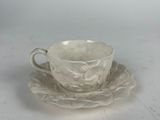 a cup and saucer on a plate on a table