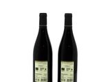 two bottles of wine sitting next to each other on a white surface