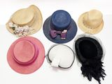 plusieurs chapeaux sont alignés sur une surface blanche