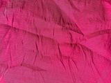 pink fabric with a bow on it laying on top of a bed