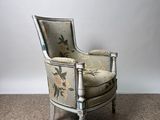 an old chair with floral upholstered upholstered back and arms