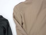 two jackets are lined up next to each other on a white surface