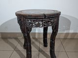 a small wooden table with a glass top on a tiled floor