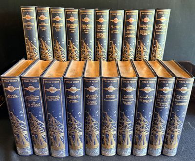 douze livres à la couverture bleue rehaussée de dorures, posés sur un fond noir