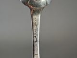 a silver spoon with a bird on it on a table