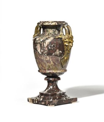 un vase posé sur un socle, sur une surface blanche