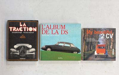 Trois livres sont alignés les uns à côté des autres sur une surface blanche