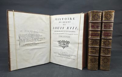 two old books sitting on top of a table next to each other