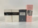 four different perfumes are lined up on a white surface