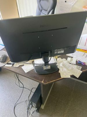 a computer monitor sitting on a desk with papers all over it