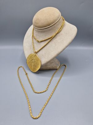 un collier en or et une pièce d'or sur un mannequin