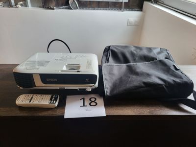 un projecteur posé sur une table à côté d'un sac