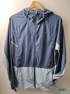 the jacket is hanging on a hanger on the wall