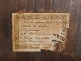 a piece of paper with writing on it on a wooden surface