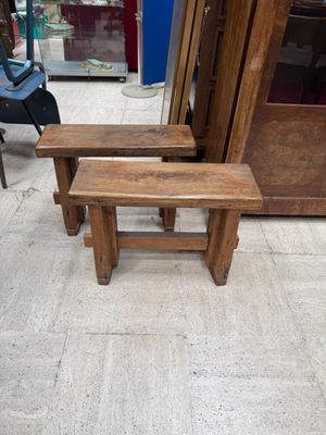 two wooden benches sitting next to each other on the floor