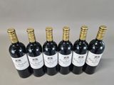 six bottles of wine are lined up in a row on a table