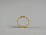 a gold ring on a white surface