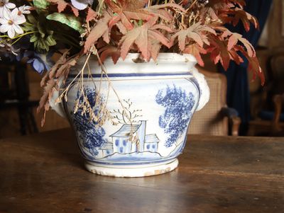 des fleurs dans un vase bleu et blanc posé sur une table en bois
