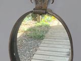 un petit miroir accroché au mur à côté d'une passerelle en bois