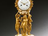 une horloge en or posée sur un socle en marbre
