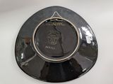 a black plate with a gold rim on a white table