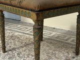 a small bench that is sitting on a cobblestone floor