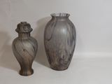 deux vases posés l'un à côté de l'autre sur une surface blanche