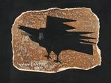 un oiseau noir perché sur une feuille de papier