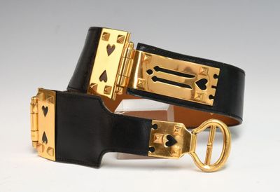 black and gold leather belt with a gold buckle on a white background