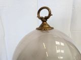 a glass dome with a metal handle on a table