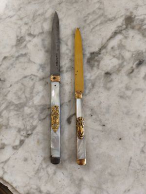 deux couteaux posés sur une table en marbre