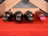 several bottles of wine are lined up on a red table cloth