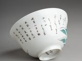 a white bowl with writing on it sitting on a table