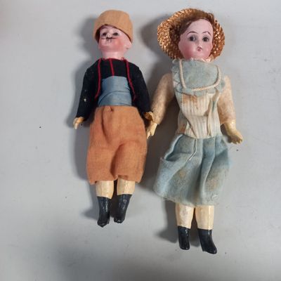 deux poupées assises côte à côte sur une table