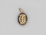 un pendentif plaqué or orné d'un monogramme en noir et blanc