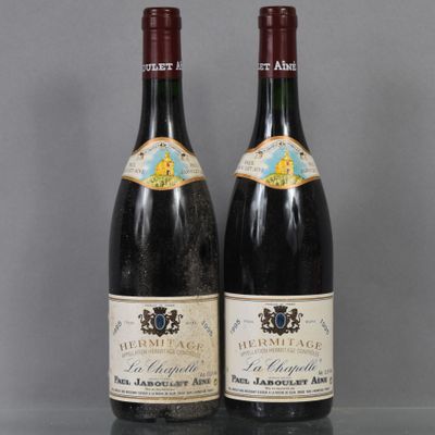 two bottles of wine sitting on top of a table next to each other