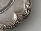 a silver plate with a handle on a white table