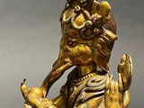brass statue of a man with a bird on his head