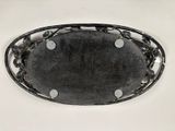 a oval metal tray with a decorative design on it