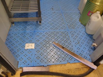 un sol en carrelage bleu avec un porte-bouteilles en métal et une bouteille d'eau