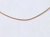 a close up of a gold necklace on a white surface