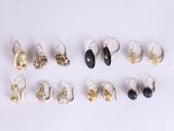 six paires de boucles d'oreilles en or et en pierre noire sur un fond blanc