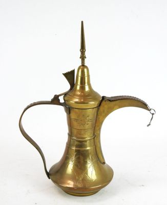 une vieille cafetière en laiton avec une anse, sur fond blanc