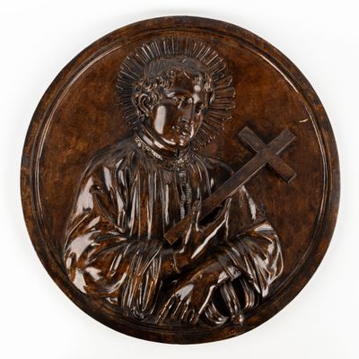 an image of a bronze plaque of a man holding a cross