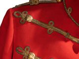 a close up of a red jacket with gold buttons on it