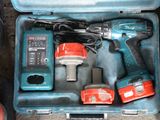 une mallette à outils bleue posée par terre, contenant des outils