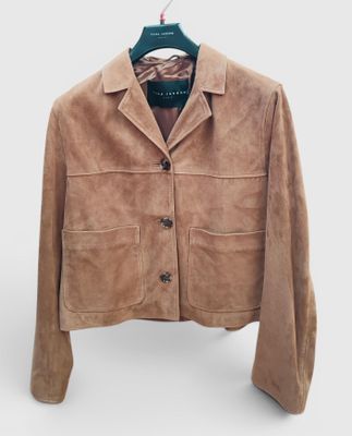 une veste marron suspendue à un cintre sur un mur blanc