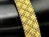 a close up of a gold bracelet on top of a black ring