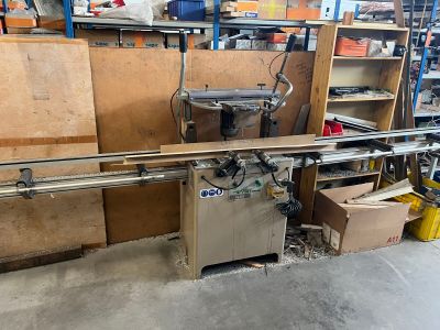 une photo d'un atelier de menuiserie avec une scie circulaire à table