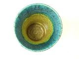 a blue and green bowl sitting on a white surface